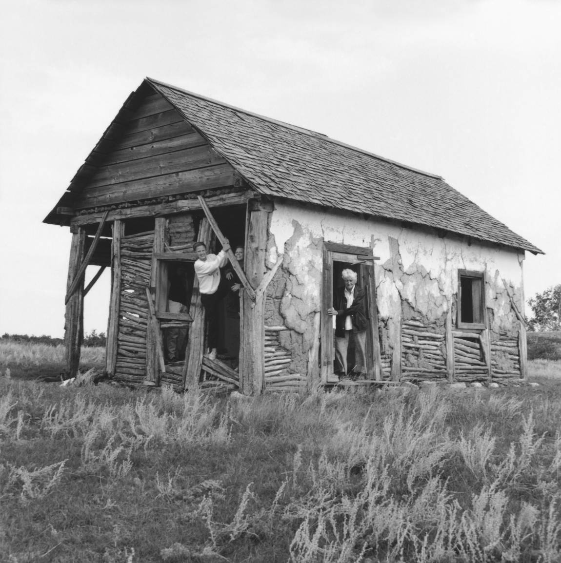 Black and white photo of elderly woman and daughter inside the elderly woman’s old farm house.