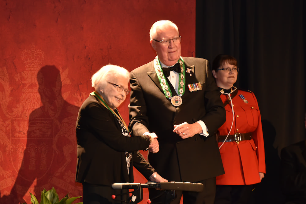 Thelma at 93 years old receiving award. Shaking hands.